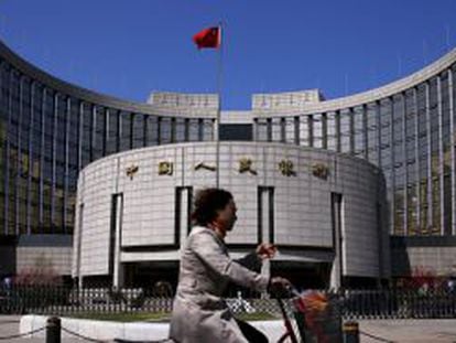 Mulher passa em frente à sede do Banco Popular da China, em Pequim.