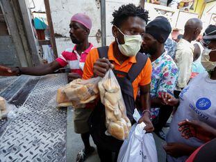 People take food distributed from a truck by a Haitian government program amid the spread of the coronavirus disease (COVID-19), in Port-au-Prince, Haiti April 6, 2020. REUTERS/Jeanty Junior Augustin