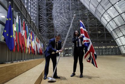 Dois funcionários retiram a bandeira britânica da sede do Conselho Europeu, nesta sexta em Bruxelas.