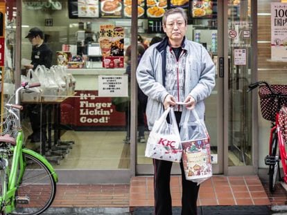 Um homem sai de um KFC em Tóquio (Japão) com seu menu natalino.