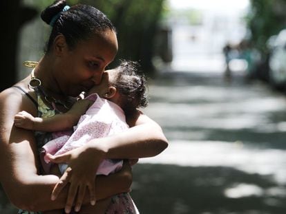 Brasileira carrega a filha afetada pelo vírus Zika.
