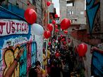 Residents of Paraisopolis, one of the city's largest slums, loose red balloons during a protest in Sao Paulo, Brazil, on December 1, 2020. - A year ago, nine people were trampled to death and twelve others were injured in a chaotic aftermath of a police raid. (Photo by Miguel SCHINCARIOL / AFP)