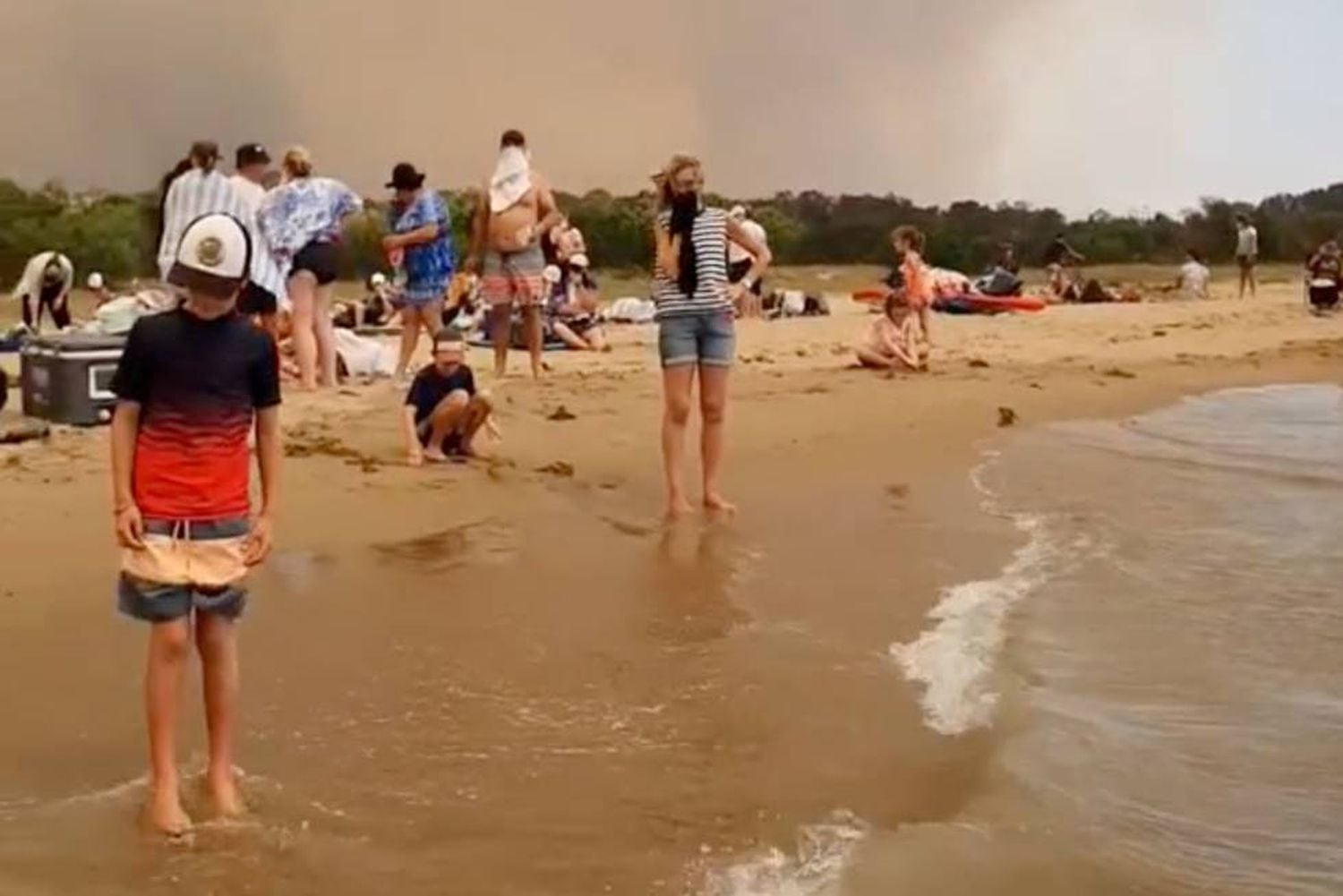 Um grupo de pessoas se refugia dos incêndios na terça-feira em Batemas Bay (Austrália).