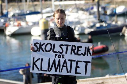 Greta Thunberg segura um cartaz onde se pode ler "Skolstrejk för klimatet" (en sueco, greve escolar pelo clima), em sua chegada a Lisboa.