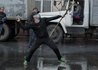 Manifestante pr&oacute;-russo atira pedra em delegacia de pol&iacute;cia.