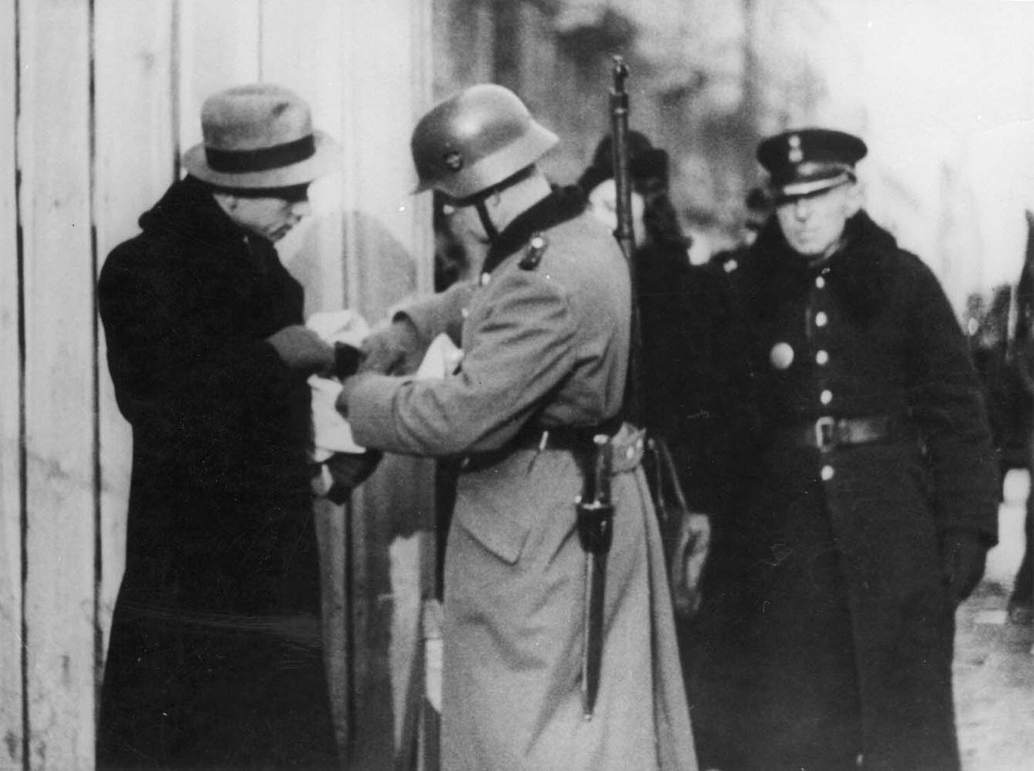 Soldados alemães e membros da Polícia Azul controlam a entrada do Gueto de Varsóvia em 1941.