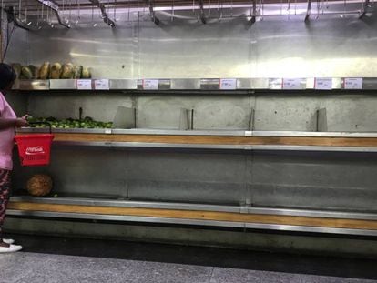 Mulher seleciona lim&otilde;es em um supermercado em Caracas.