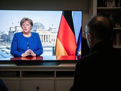 Alemão assiste a Merkel falar na TV.