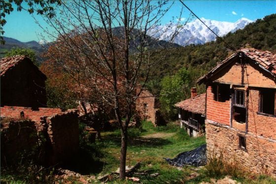 Vista de algumas das casas de Porcieda (Cantabria), aldeia abandonada com os Picos de Europa ao fundo, à venda por 1,5 milhões de euros.