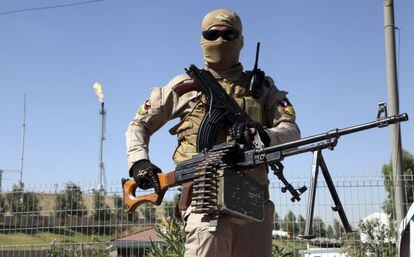 Integrante das forças de segurança curdas vigia refinaria perto de Mossul (Iraque).