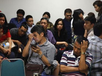 Familiares dos passageiros esperam notícias no aeroporto de Surabaya.