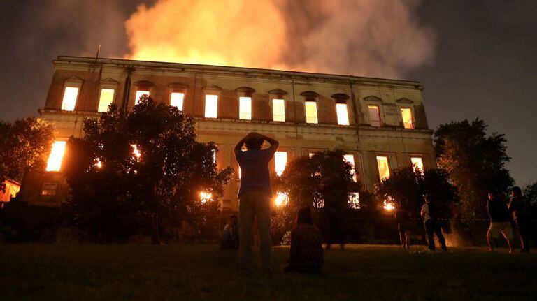 Pessoas observam como as chamas destroem o Museu Nacional.