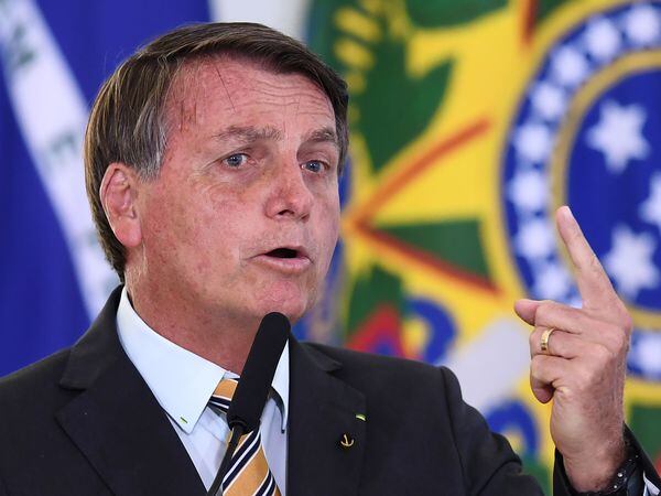 Brazilian President Jair Bolsonaro gestures as he speaks during the launch of a program for the resumption of tourism, a sector severely affected by the new coronavirus outbreak, at Planalto Palace in Brasilia, on November 10, 2020. - Brazil's decision to halt trials of a Chinese-developed Covid-19 vaccine triggered a politically charged row Tuesday as a top health official expressed "indignation" and far-right President Jair Bolsonaro claimed the ruling as a personal victory. (Photo by EVARISTO SA / AFP)