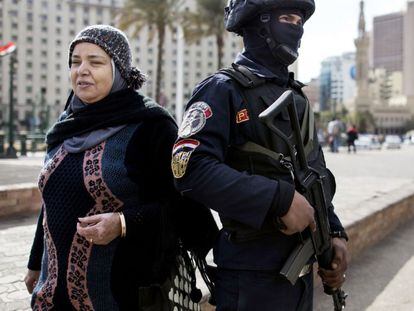 Uma mulher passa ao lado de um soldado, próximo à praça Tahrir.