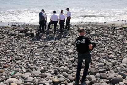 Policiais inspecionam um objeto metálico encontrado na praia de Saint-Denis, na ilha Reunião, em 2 de agosto.