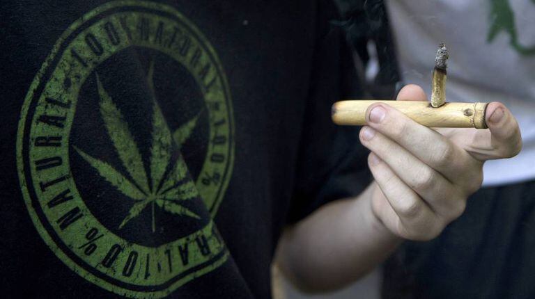 Homem fuma maconha em uma manifestação em frente ao Palácio Legislativo em Montevidéu a favor da legalização da maconha em dezembro de 2013