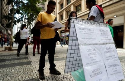 Pessoas procuram vagas de empregos em cartazes no centro de S&atilde;o Paulo.