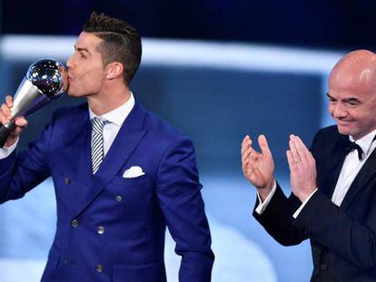Cristiano Ronaldo beija o troféu de melhor jogador de 2016 sob o olhar de Gianni Infantino, presidente da FIFA.