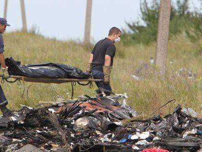 Dois ucranianos levam os restos das vítimas do voo MH17.