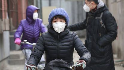 Habitantes com máscaras durante o alerta por poluição em dezembro em Pequim.