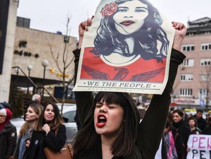 Mulher com um cartaz que diz “Nós, o povo, defendemos a dignidade”, durante manifestação em Kosovo em março.