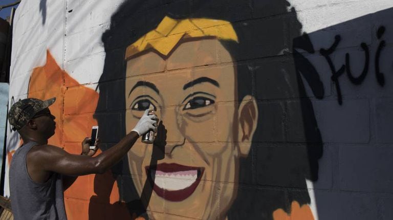 O grafiteiro Aria Crespo pinta um mural com a imagem da vereadora do PSOL Marielle Franco