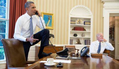 Obama fala por telefone ao lado do vice-presidente Joe Biden.
