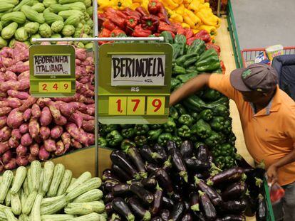 Consumidor escolhe legumes em um supermercado de São Paulo.