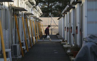 Mulher caminha pelas casas temporárias em Tamura, Fukushima.