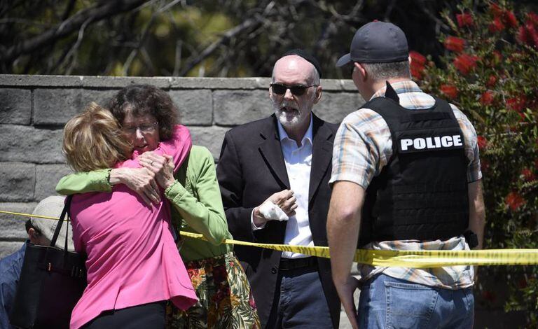 Mulheres se abraçam no exterior da sinagoga Chabad, em Poway, Califórnia.
