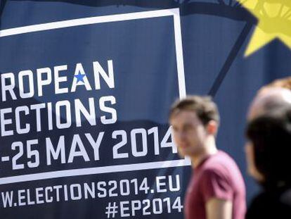 Transeuntes passam por cartaz alusivo às eleições europeias, em Bruxelas.