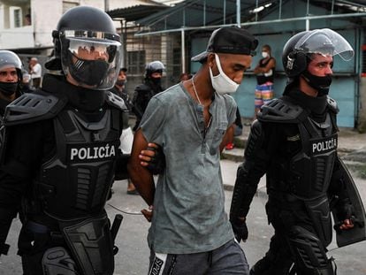Policiais conduzem um homem detido nos protestos sociais em Cuba, em Havana, em 13 de julho.