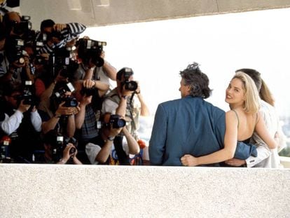 No Festival do Cannes de 1992, Sharon Stone, prestes a se tornar uma estrela mundial, dedica um sorriso a um fotógrafo enquanto seus colegas da equipe em ‘Instinto Selvagem’ posam para outros.