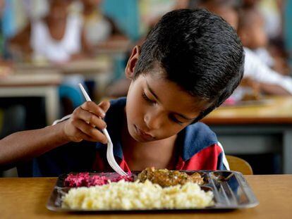 Um menino almoça num refeitório escolar de Higuerote, em agosto.