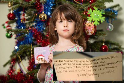 Florence Widdicombe, de seis anos, posa com o cartão natalino da Tesco onde encontrou a mensagem de um preso estrangeiro na China.