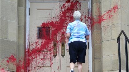 Uma fiel se aproxima da entrada da igreja presbiteriana Grace, atacada com tinta vermelha em Calgary, no dia 3.
