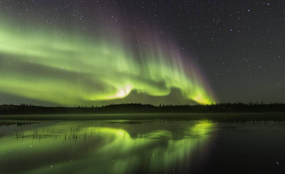 Aurora boreal refletida no lago Prosperous, ao norte de Yellowknife, capital dos Territórios do Noroeste (Canadá).
