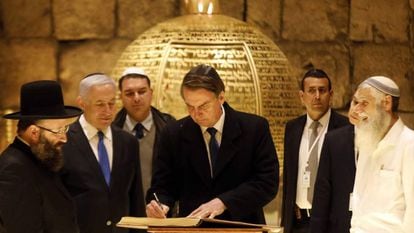 Bolsonaro assina livro ao lado do primeiro-ministro israelense Benjamin Netanyahu e do rabino Shmuel Rabinovitch em visita a sinagoga na Cidade Velha de Jerusalém, no dia 1º de abril