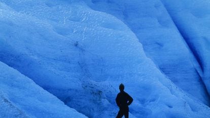 Um turista diante do gelo azul do glaciar Svartisen, ao norte de Noruega.
