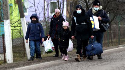 Una familia ucrania se dirige al paso fronterizo de Shehyni, en Ucrania, hacia Polonia.