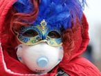 Masked carnival reveller wears protective face mask at Venice Carnival, which the last two days of, as well as Sunday night's festivities, have been cancelled because of an outbreak of coronavirus, in Venice, Italy February 23, 2020.  REUTERS/Manuel Silvestri