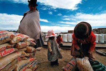 Família boliviana recebe alimentos em La Quiaca, um povoado argentino na fronteira com a Bolívia