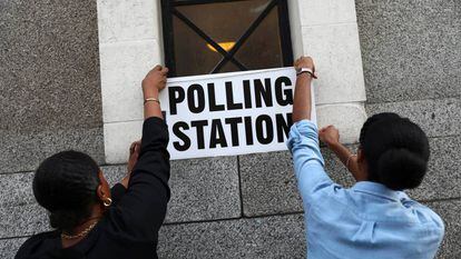 Trabalhadores colocam cartazes em um colégio eleitoral de Londres.