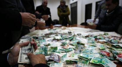 Palestinos contam o dinheiro arrecadado para reconstruir as casas de familiares de terroristas.
