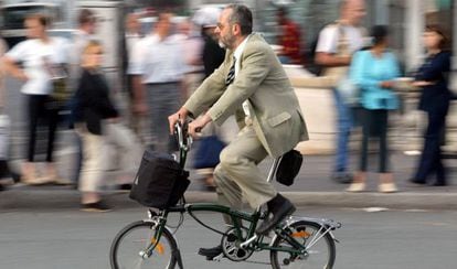Um homem anda de bicicleta em Paris (França).