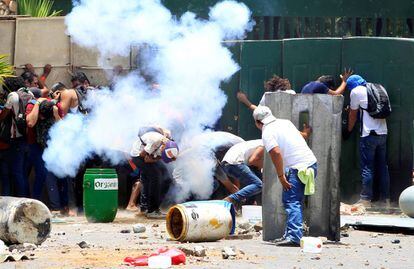 Manifestantes se protegem durante os protestos na Universidade Agrária de Manágua.