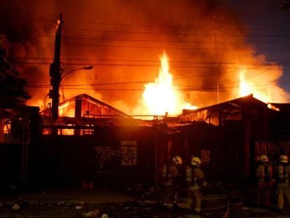 Bombeiros combatem incêndio em um armazém durante os distúrbios no Chile.