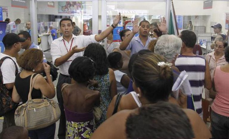 Funcionários pedem calma a clientes em uma agência do Bradesco no Rio de Janeiro.