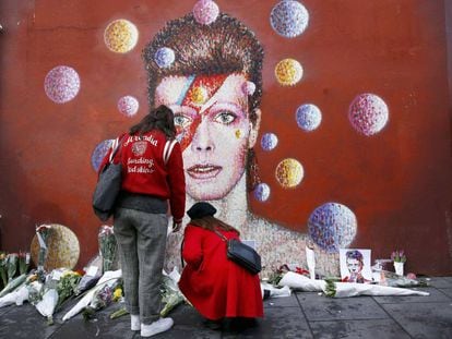 Mulheres deixam flores diante do mural de David Bowie em Brixton, no sul de Londres.