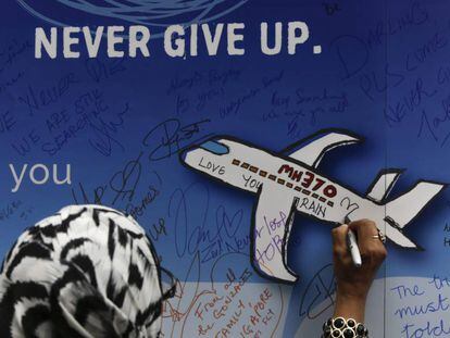 Mulher deixa uma mensagem em um memorial das v&iacute;timas do voo MH 370 em Kuala Lumpur, na Mal&aacute;sia, em mar&ccedil;o de 2016. 